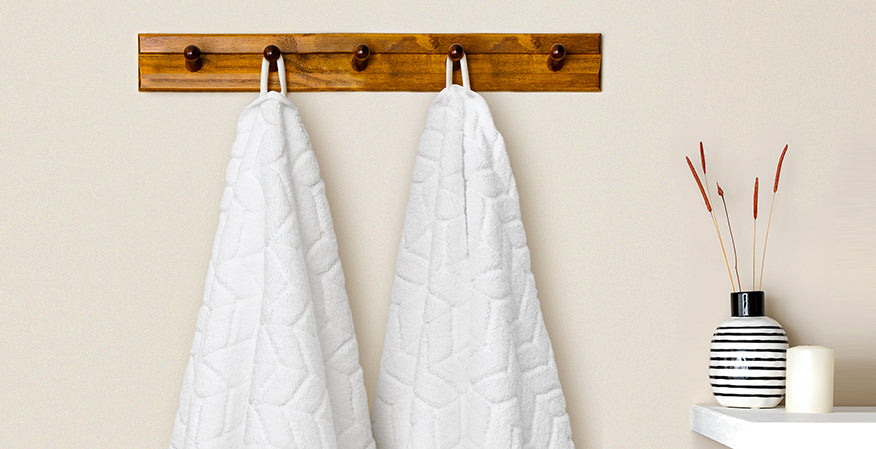 White Alusa Home Chevron Collection towels hanging from their built-in loops